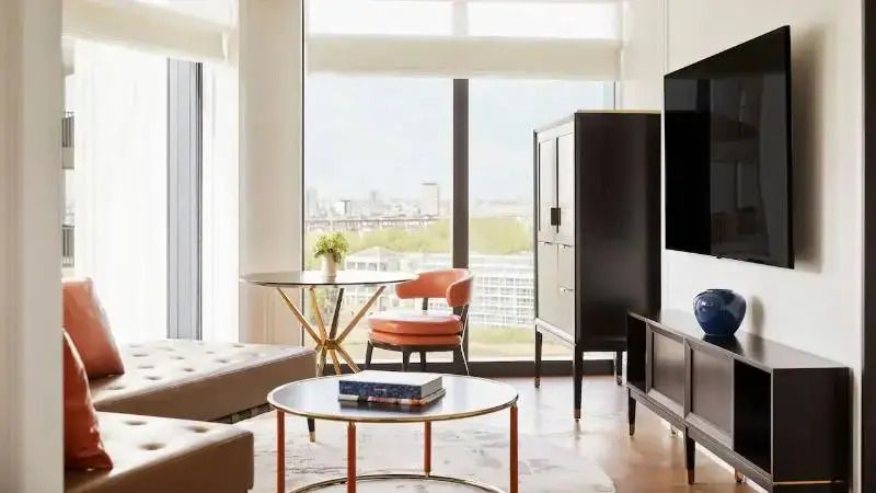 Helles Wohnzimmer in der Suite mit Blick auf die Stadt durch große Fenster