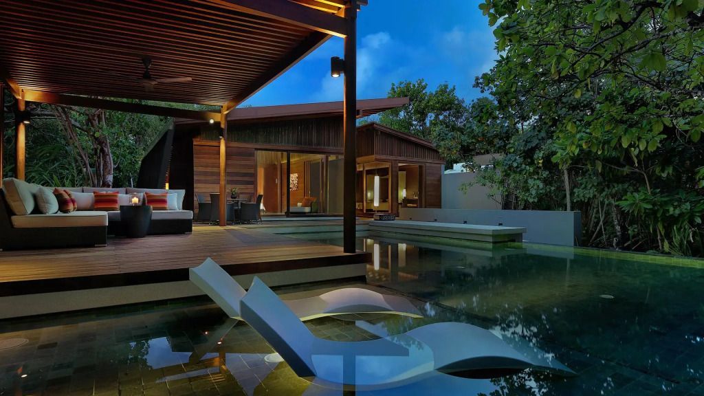Abendstimmung im Außenbereich der Villa mit beleuchtetem Pool