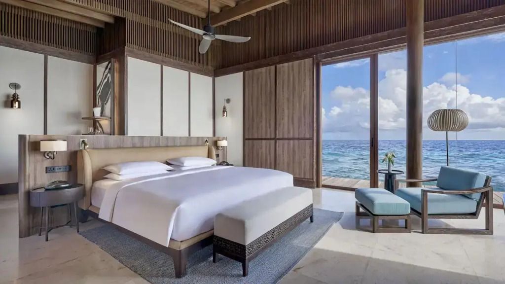 Elegantes Schlafzimmer mit Blick auf das Meer und luxuriösem Doppelbett im Park Hyatt Maldives.