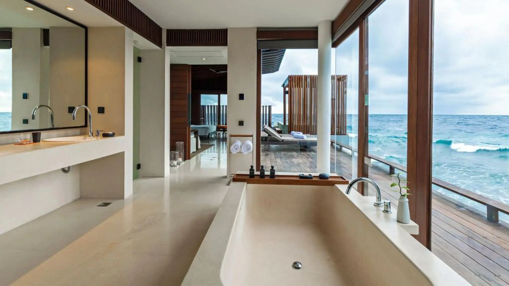 Luxuriöses Badezimmer mit freistehender Badewanne und Blick auf das Meer