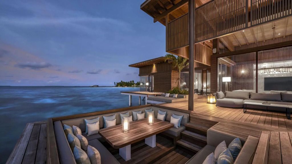Abendliche Terrasse am Wasser mit gemütlicher Sitzgelegenheit und Beleuchtung