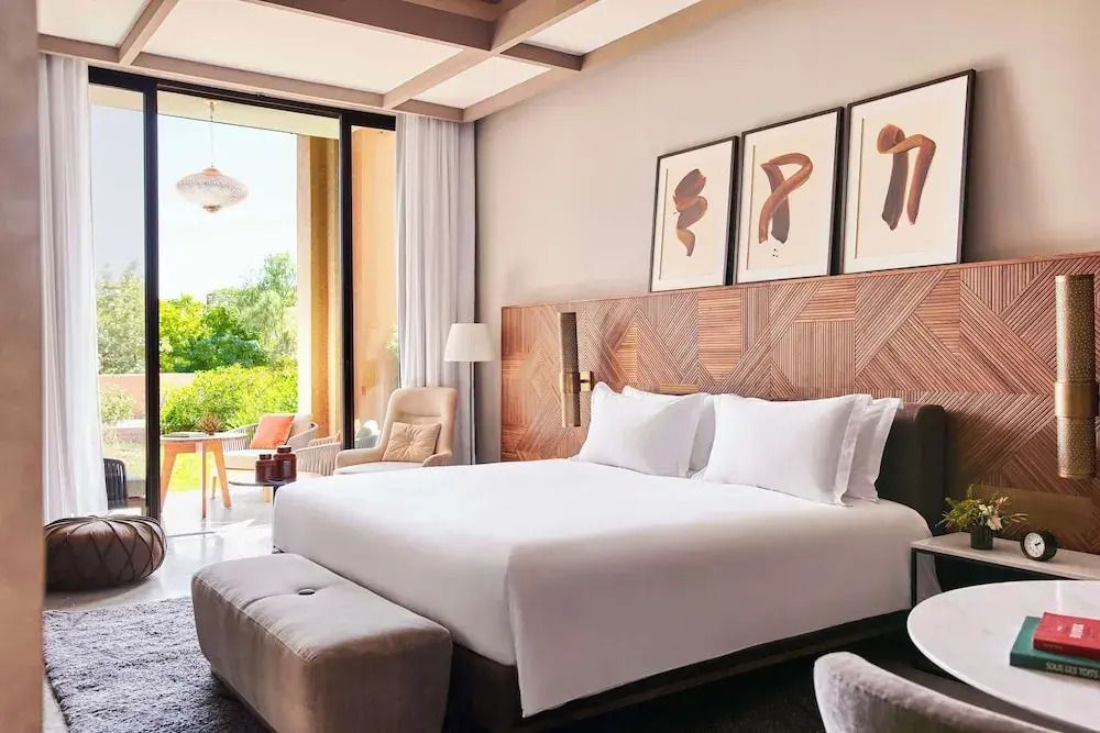 Großer Raum mit modernem Doppelbett und Aussicht auf den privaten Balkon