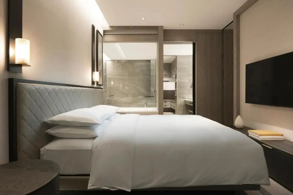 Elegantes Schlafzimmer der Suite mit Blick auf das luxuriöse Badezimmer.