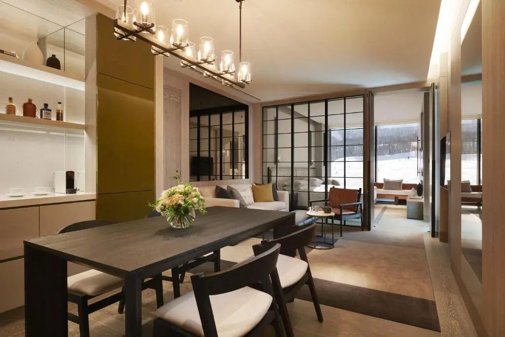 Eleganter Wohnbereich mit Esstisch und gemütlicher Sitzecke mit Glasfront zum Ausblick