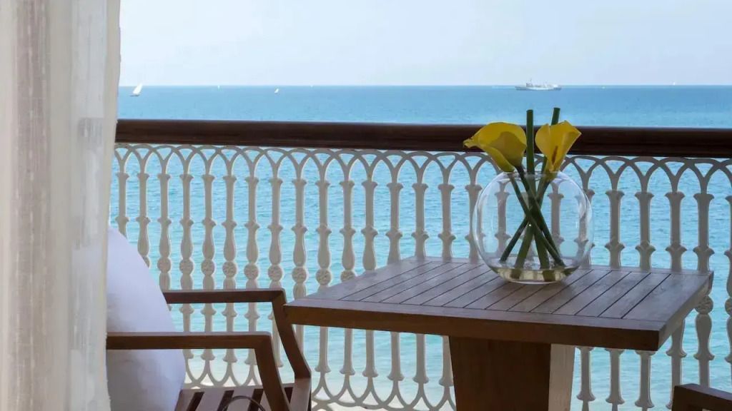 Balkon mit Meerblick und eleganter Holzbestuhlung
