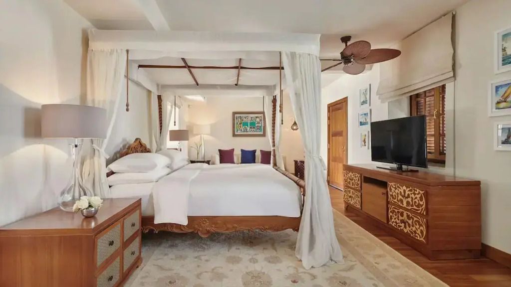 Geräumiges Schlafzimmer mit Himmelbett und modernen Annehmlichkeiten in der Zanzibar Suite.