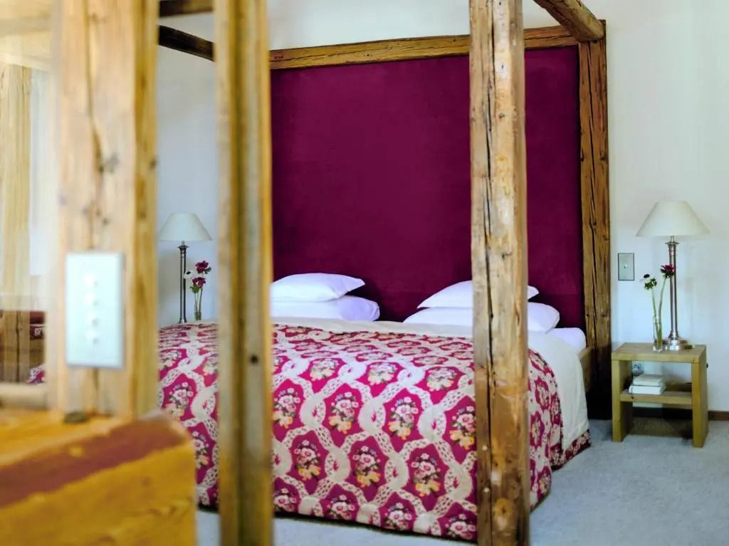 Deluxe Suite mit Himmelbett und roter Wanddekoration