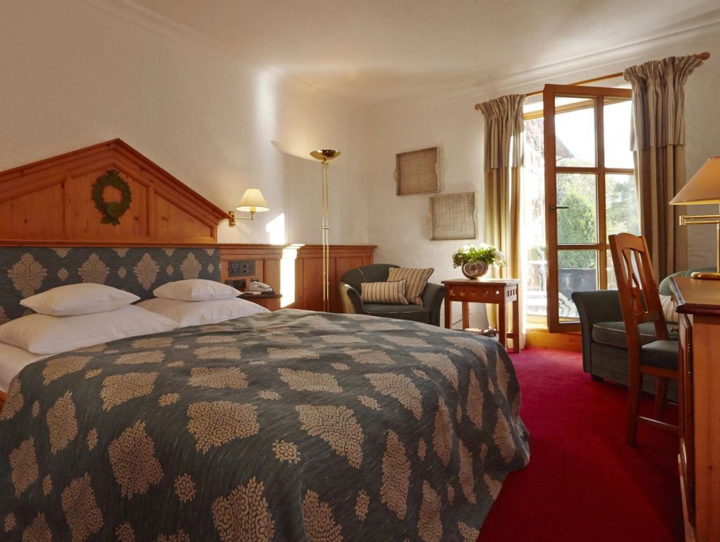 Helles Doppelzimmer mit gemütlichem Doppelbett und Zugang zu einem Balkon