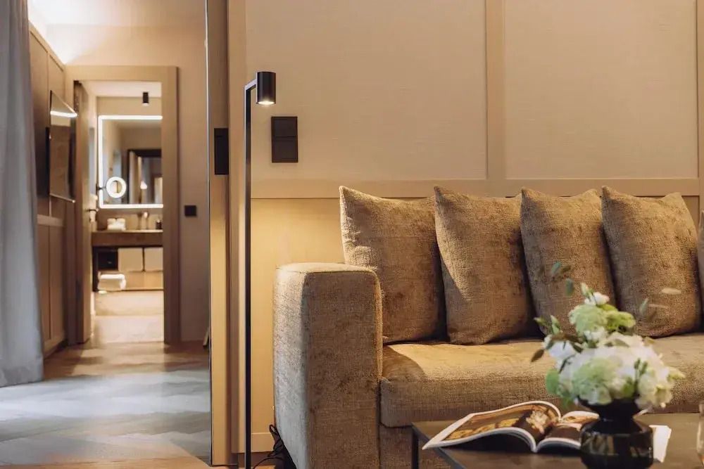Gemütlicher Wohnbereich mit Stehlampe und Sofa in der Suite