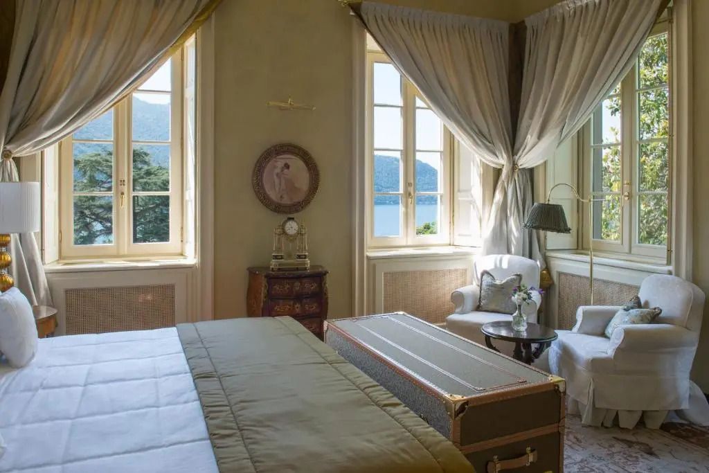 Luxuriöses Schlafzimmer mit Blick auf den See durch große Fenster, klassisches Interieur