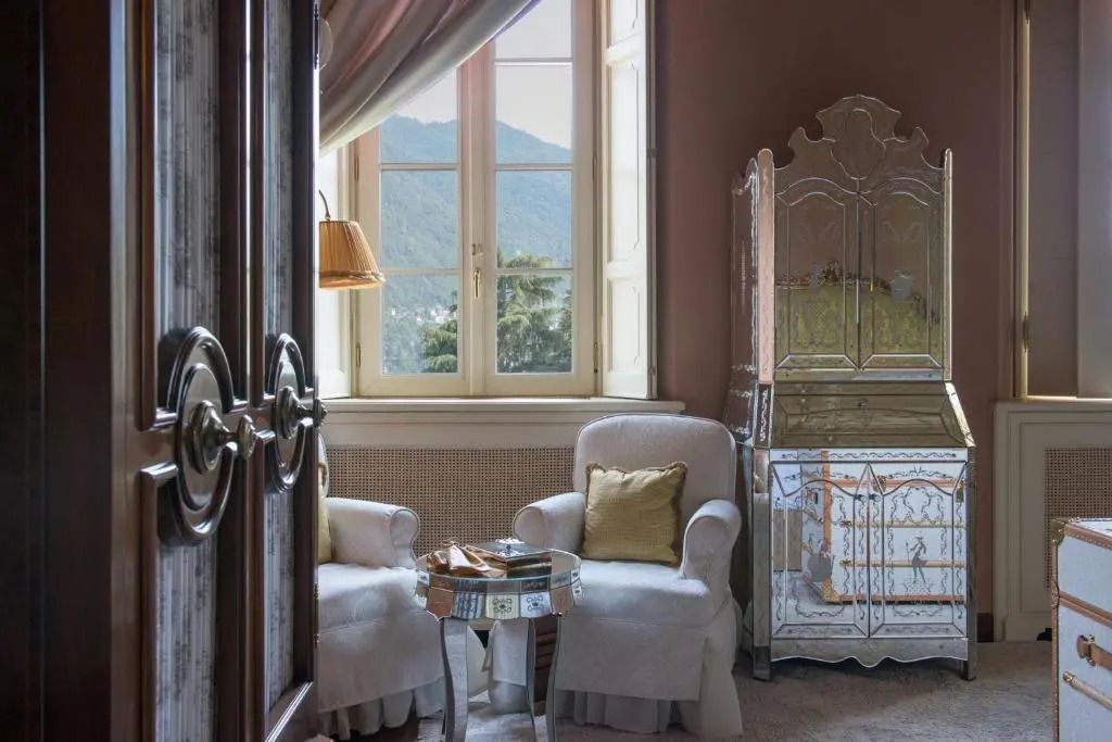 Sitzecke vor Fenster mit Seeblick, elegantes Möbel und Bergansicht