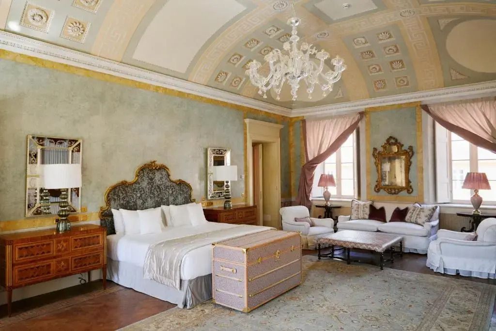 Luxuriöse Junior-Suite mit opulenter Deckenverzierung und großem Bett