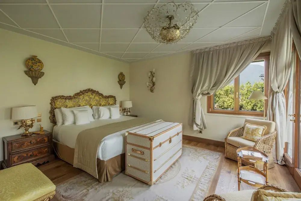 Geräumiges Zimmer mit luxuriösem Bett und dekorativem Koffer am Fußende