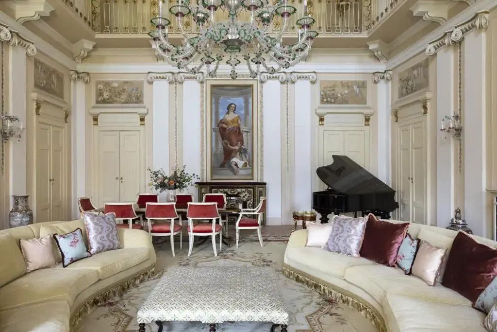 Eleganter Wohnbereich der Präsidenten Suite mit Klavier und roten Stühlen
