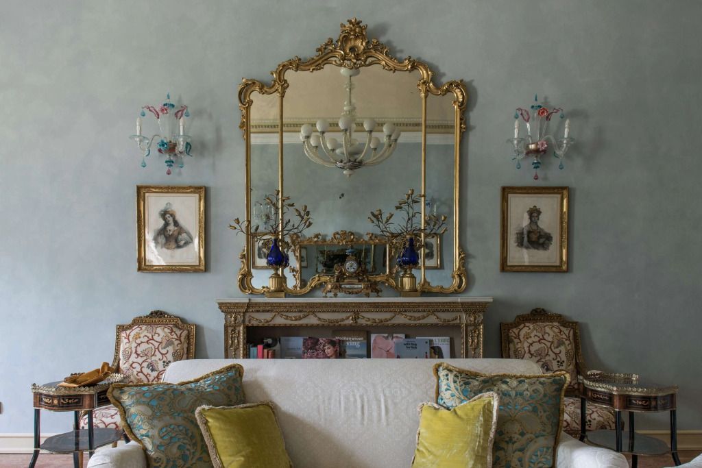 Prächtiger Spiegel mit Goldrahmen über einer eleganten Couch in der Suite