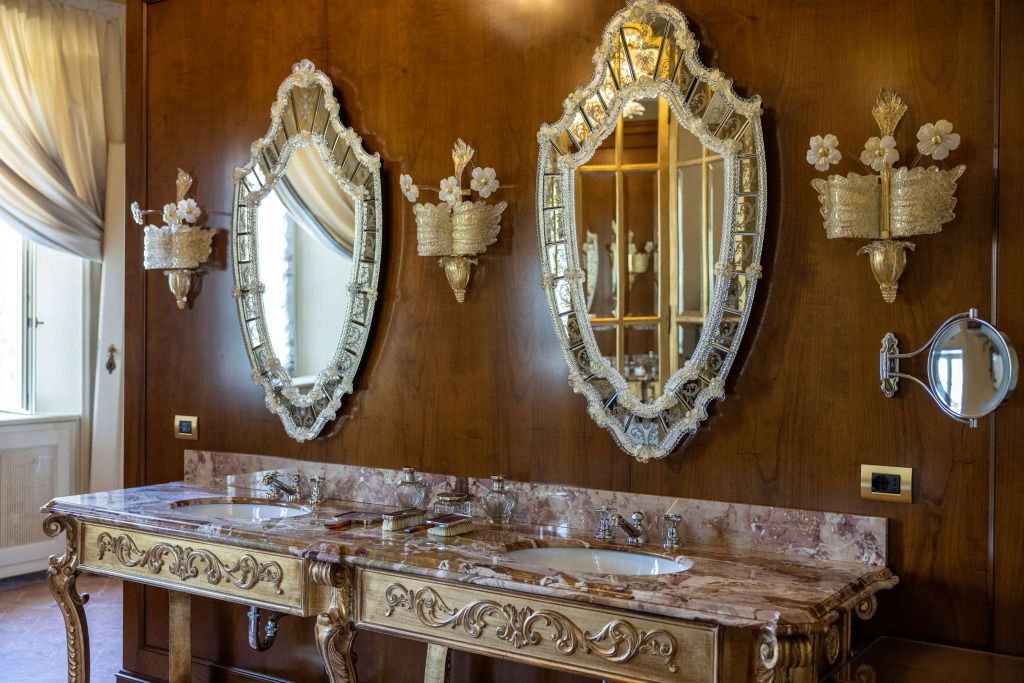 Luxuriöse Badezimmerausstattung mit vergoldeten Spiegelrahmen und Doppelwaschtisch.