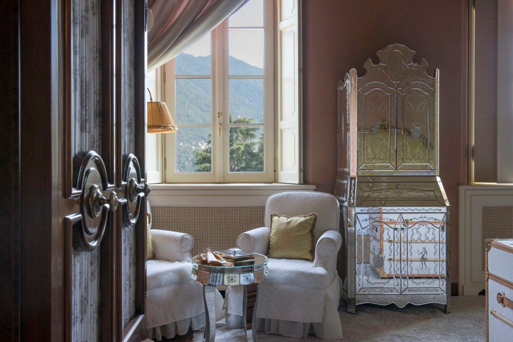 Gemütliche Sitzecke in einem Zimmer mit antiken Möbeln und Seeblick.