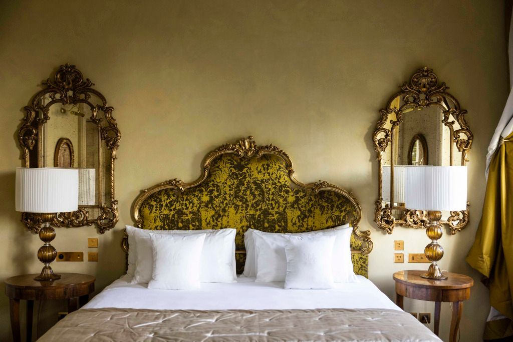Elegantes Bett mit kunstvoll verzierten Spiegeln und luxuriösen Kissen.