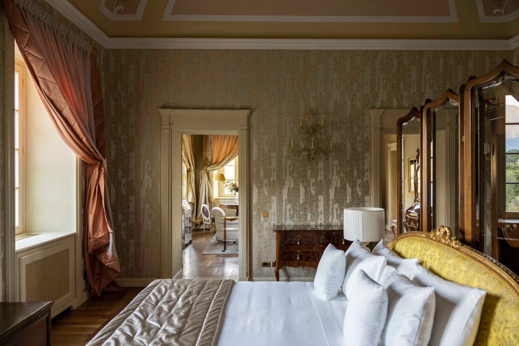 Geräumiges Schlafzimmer mit stilvollen Tapeten und klassischem Dekor.