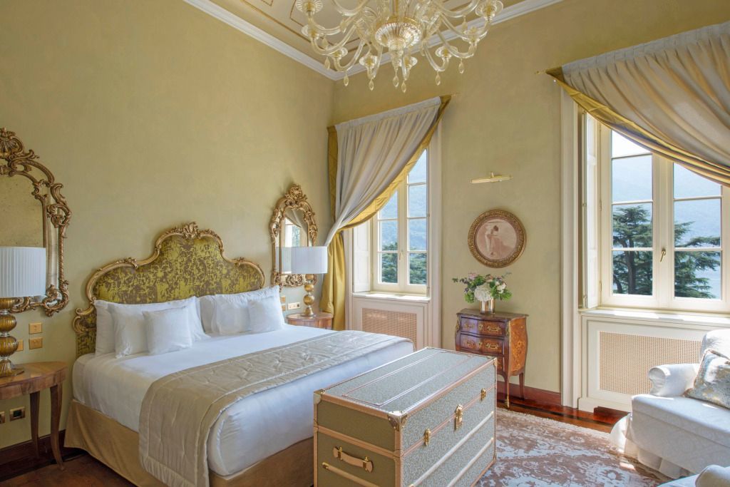 Helles Zimmer mit großem Bett, antiken Möbeln und stilvollen Details.