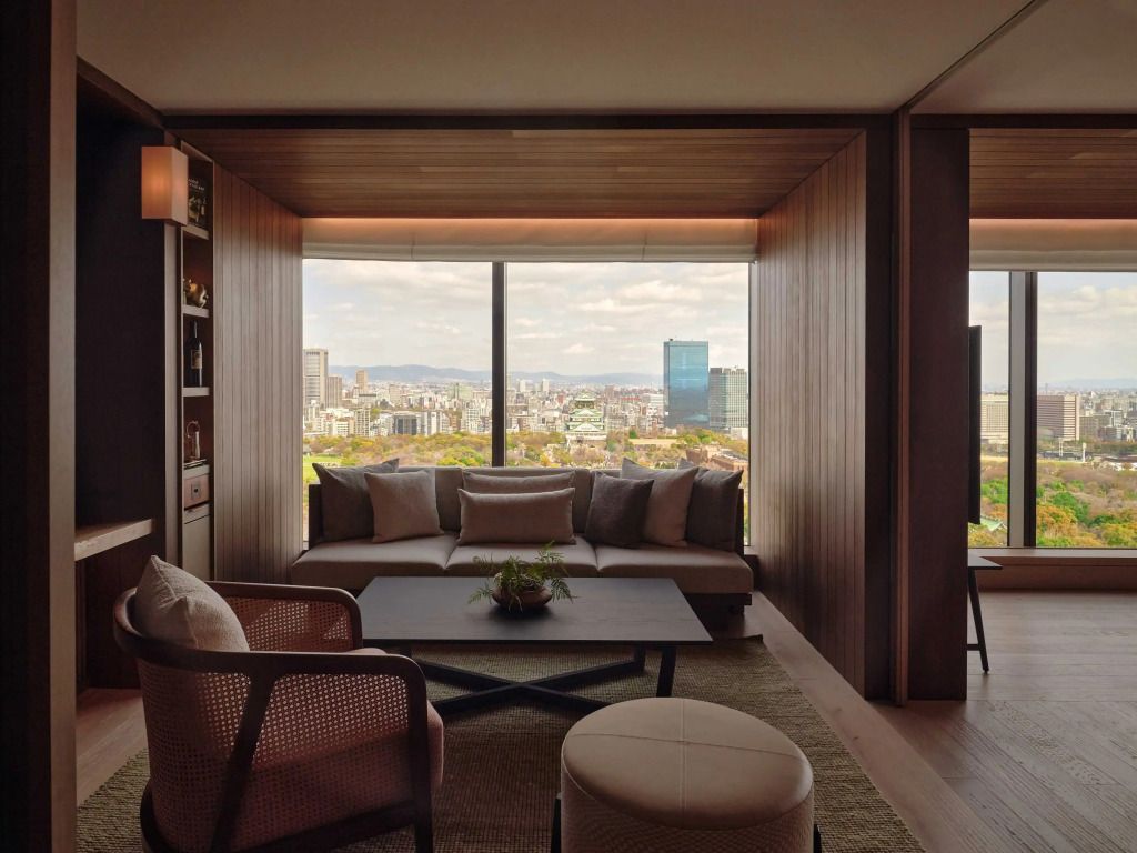 Elegantes Zimmer mit großer Fensterfront und Blick auf Osaka