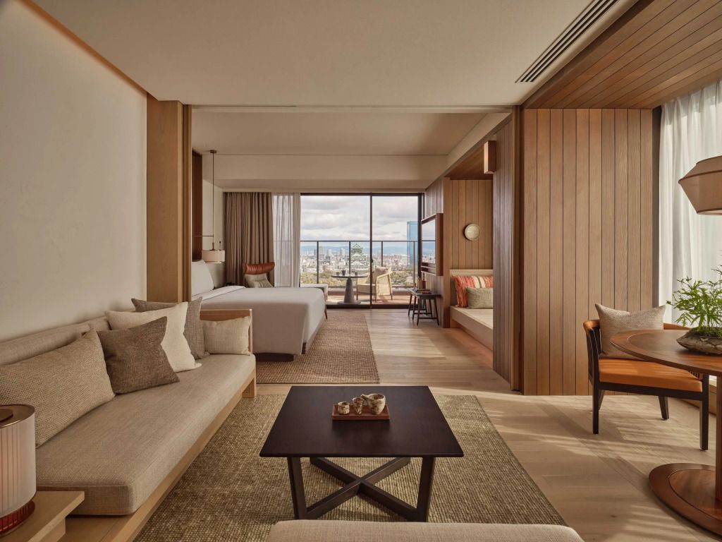Helle Suite mit Doppelbett, modernem Sofa und Blick auf die Skyline von Osaka