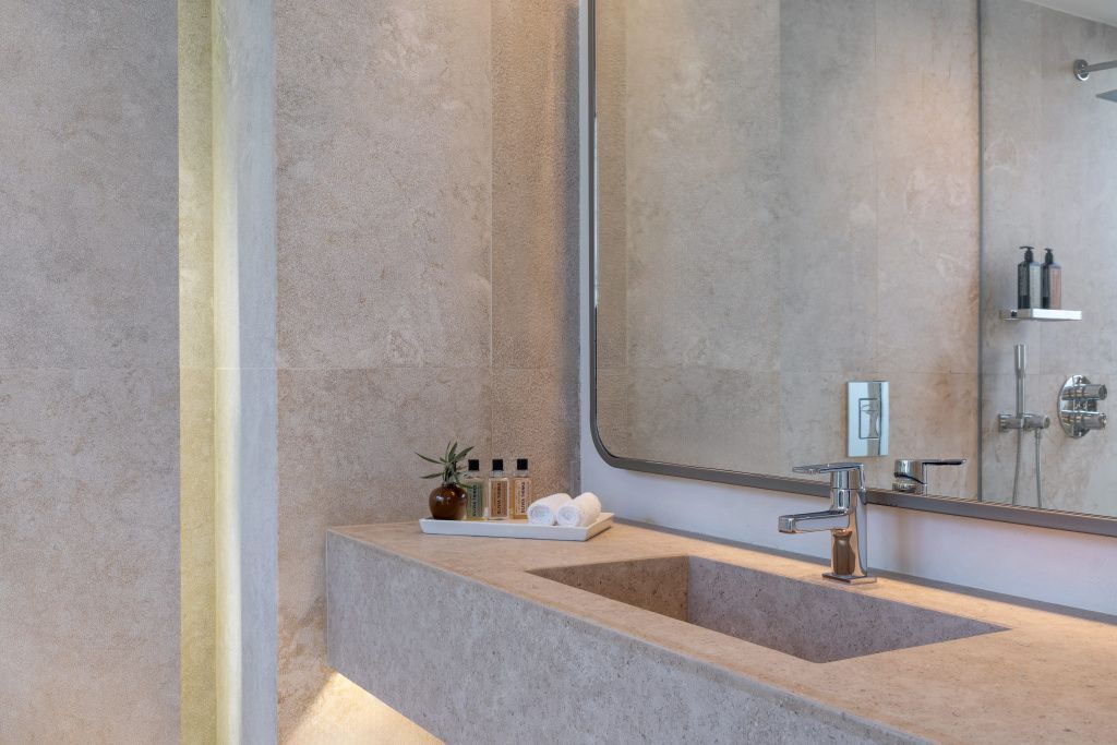 Luxuriöses Badezimmer im Patmos Aktis Resort mit edlem Waschtisch aus Naturstein.
