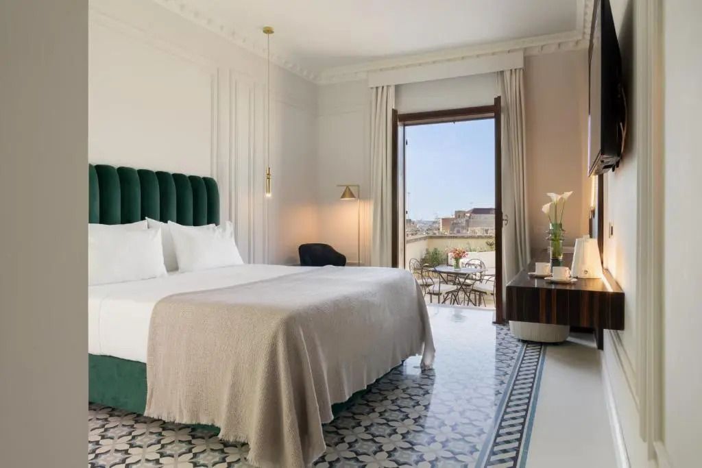 Stilvolles Hotelzimmer mit Fliesenboden und herrlicher Aussicht von der Terrasse.
