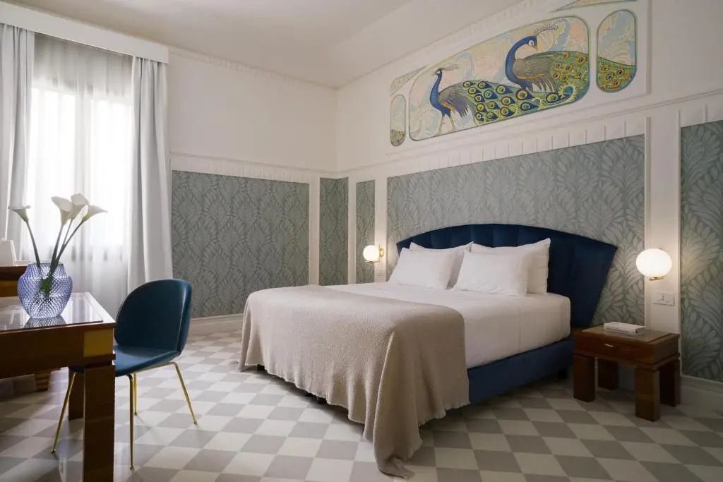 Komfort Doppelzimmer mit Doppelbett und eleganter Wandmalerei mit Pfauenmotiv