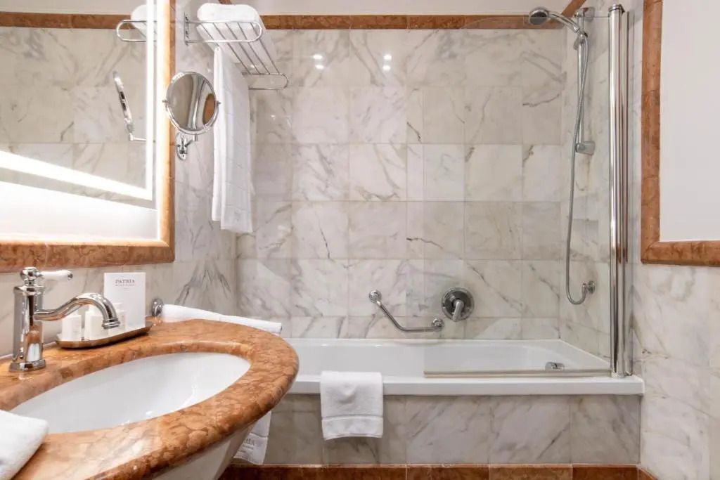 Hochwertig gefliestes Badezimmer mit Badewanne und eleganten Armaturen