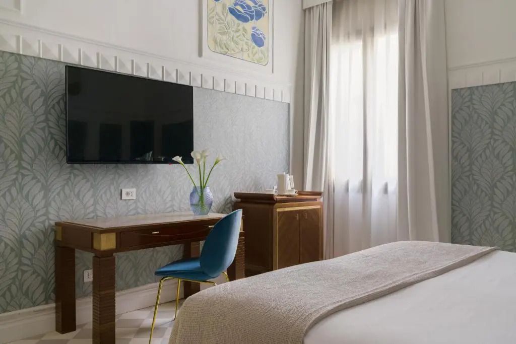 Helles Zimmer mit großem Fernseher, Schreibtisch und natürlichem Licht