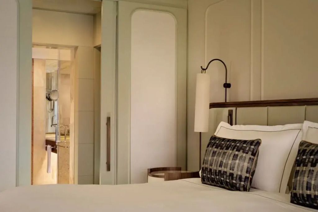 Detail des Bettes mit eleganter Wandlampe im Deluxe Zimmer