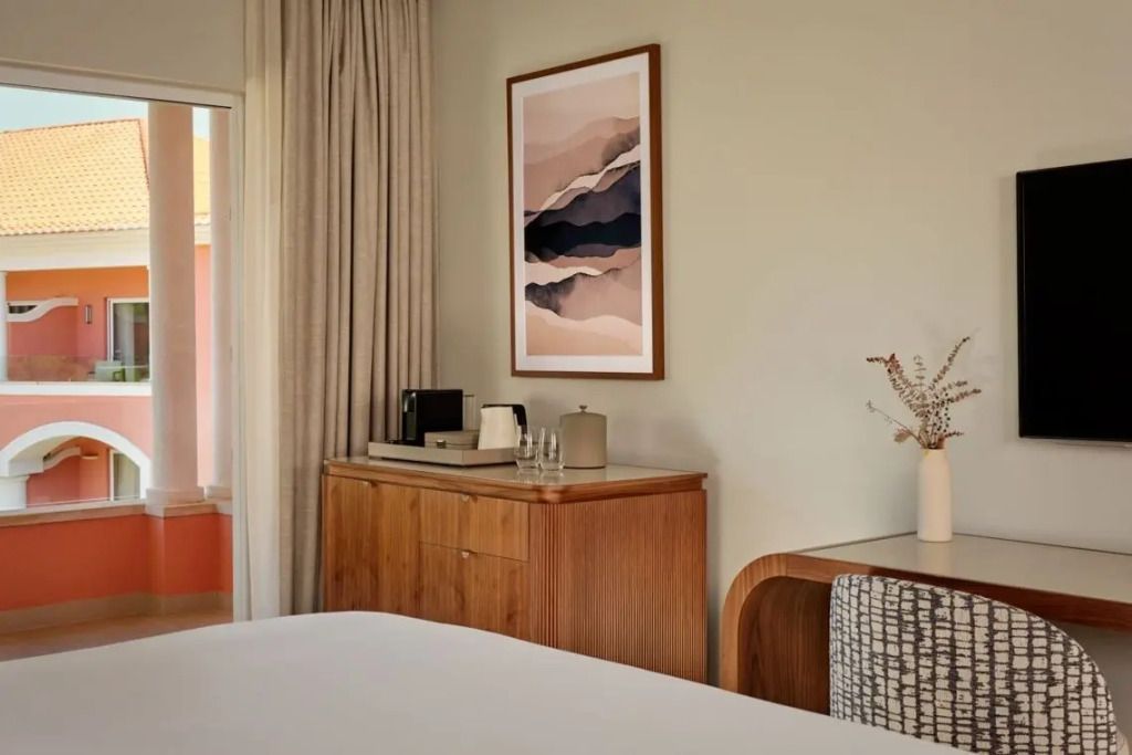 Holzkommode mit Kunstwerk und Kaffeemaschine im Deluxe Zimmer