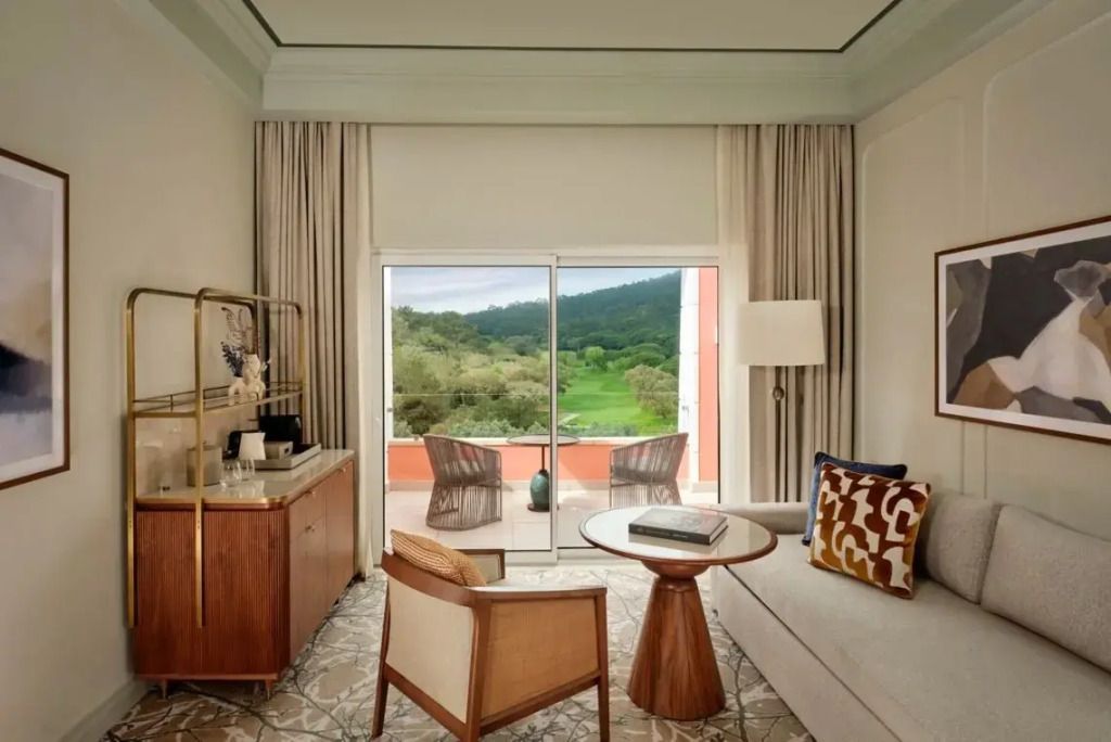 Sitzbereich in einer Suite mit Blick auf einen Balkon und Landschaft