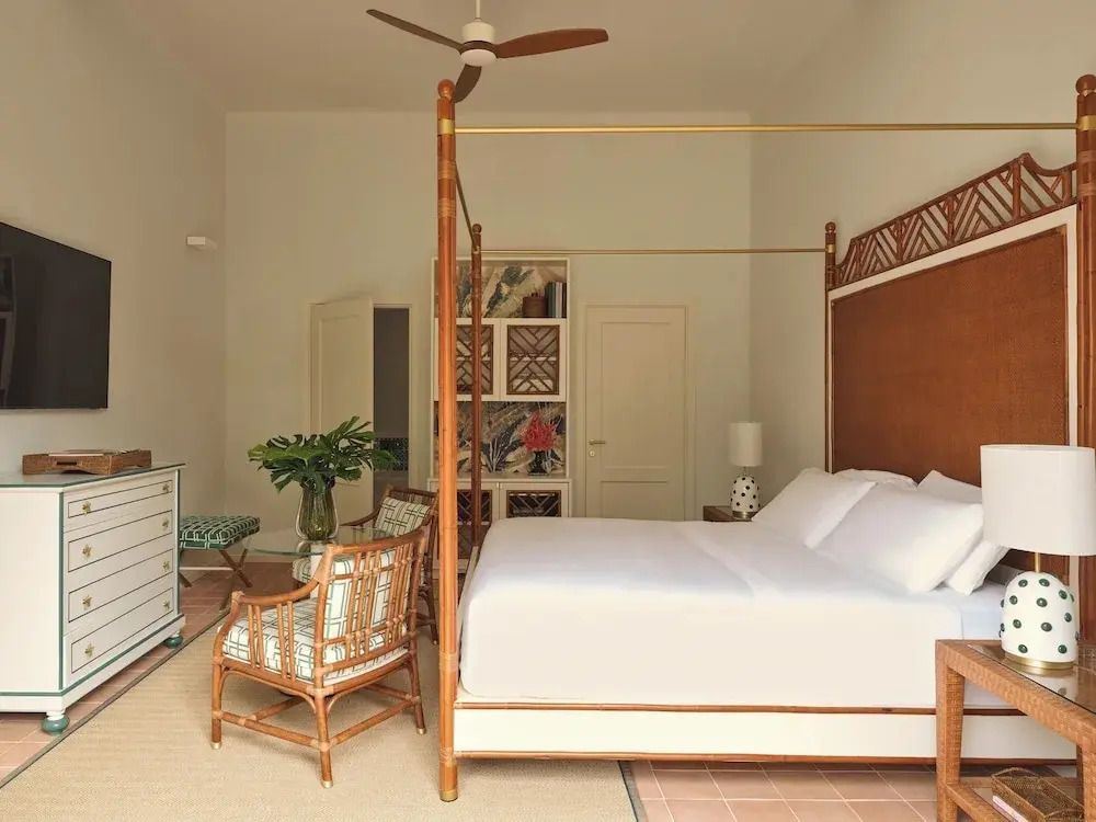 Helles Standardzimmer mit Himmelbett und Rattanmöbeln im Hotel Pensione America