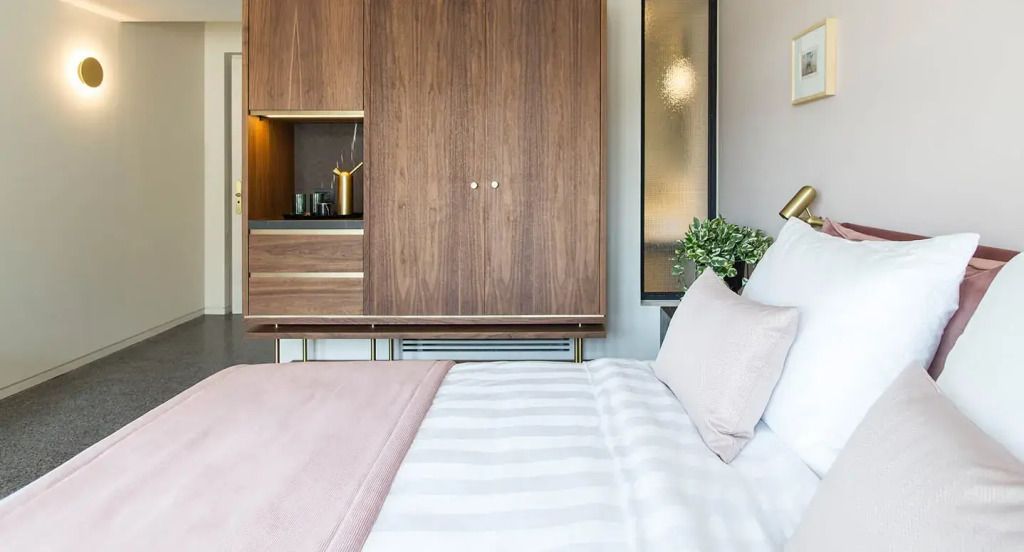 Modernes Hotelzimmer mit Holzmöbeln und bequemer Bettwäsche