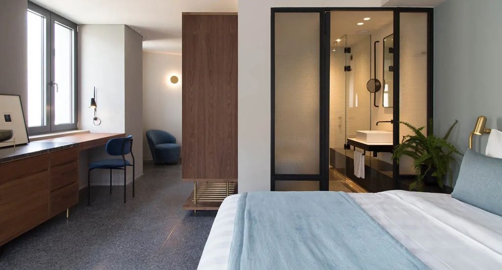 Junior-Suite mit modernem Bad und Sitzbereich in warmer Beleuchtung