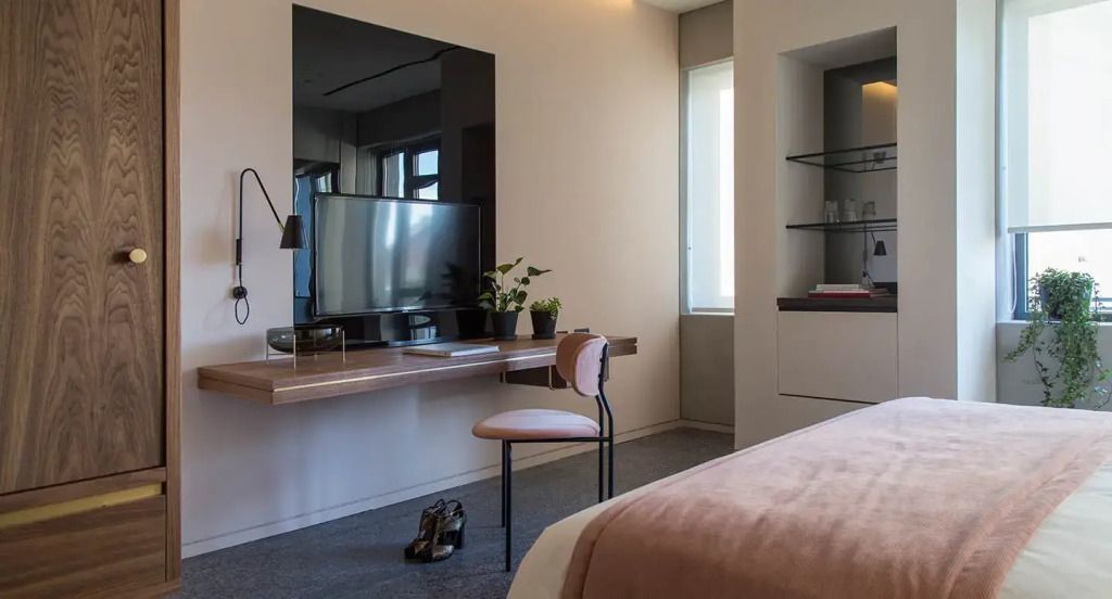 Moderner Schreibtisch mit Flachbildfernseher und Pflanzen im Hotelzimmer