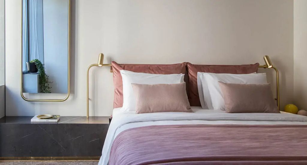 Doppelbett mit rosa Akzenten und luxuriöser Bettwäsche im Hotelzimmer