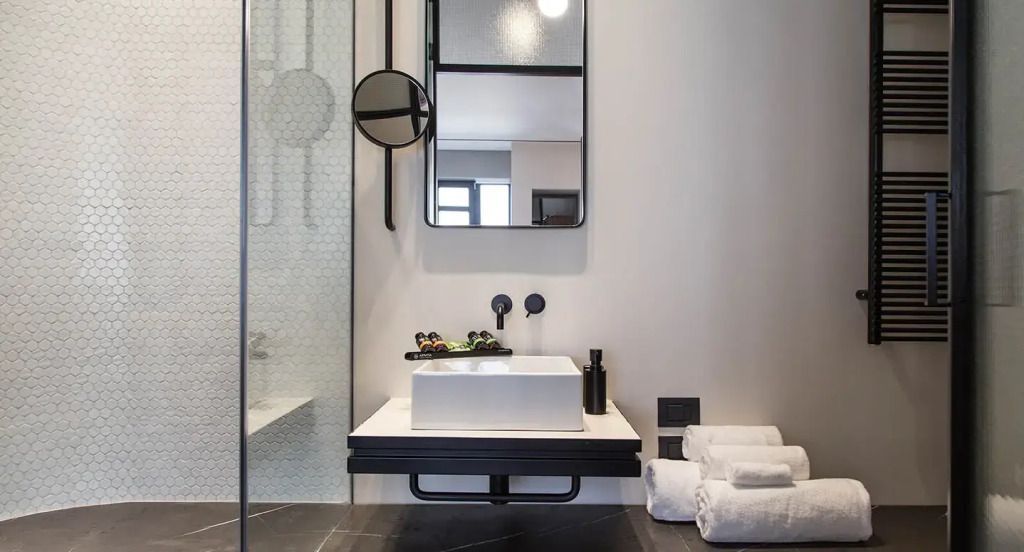 Modernes Badezimmer, Waschbecken mit Handtüchern und Dusche im Hintergrund