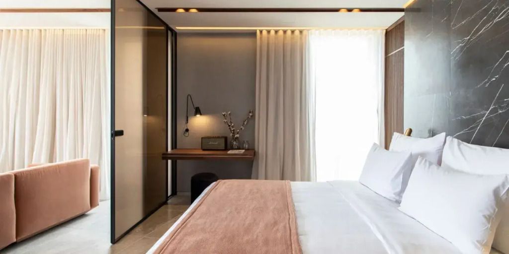 Zimmer mit Schreibtisch, eleganter Beleuchtung und Zugang zum Balkon