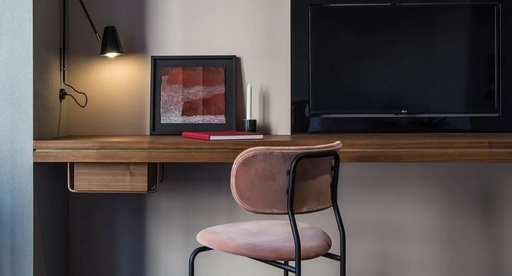 Arbeitsbereich mit modernem Schreibtisch und Kunstwerk.