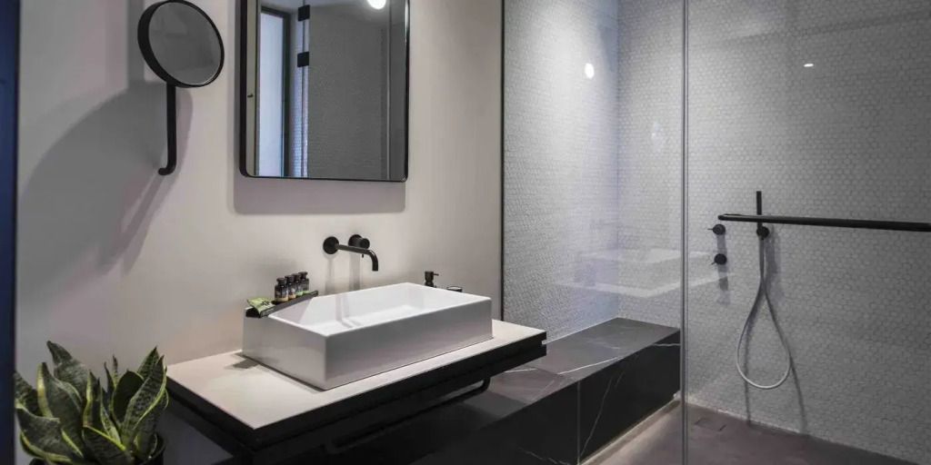 Modernes Badezimmer mit großem Spiegel und stilvollem Waschbecken.