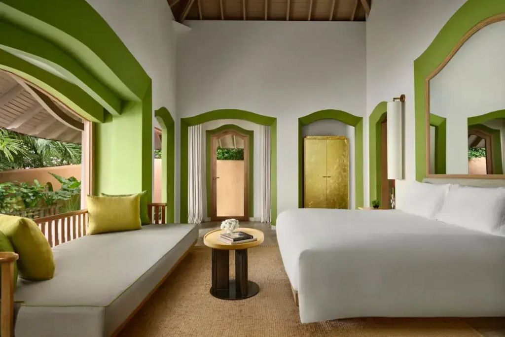 Moderne Villa mit gemütlichem Doppelbett und eleganter Einrichtung in Grün- und Weißtönen.