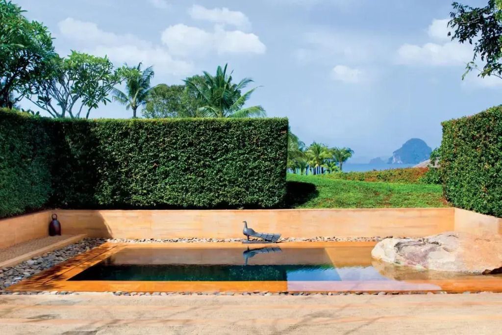 Privater Garten mit Pool und üppiger Vegetation im Hintergrund.