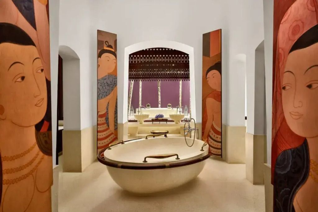 Großes Badezimmer mit freistehender Badewanne und kunstvoller Wanddekoration