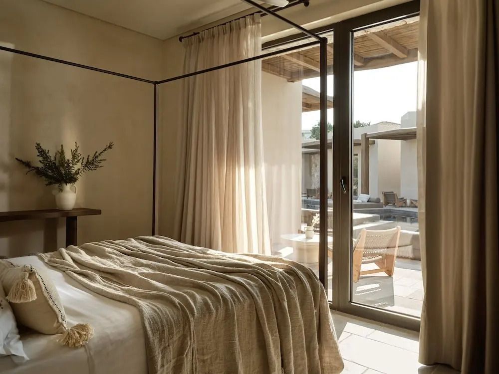 Helles Schlafzimmer mit Zugang zur Terrasse und natürlichem Licht in der Deluxe Suite