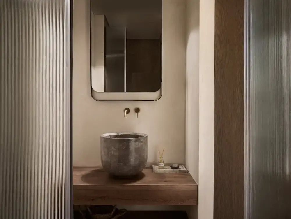 Elegantes Badezimmer mit Steinwaschbecken und moderner Armatur
