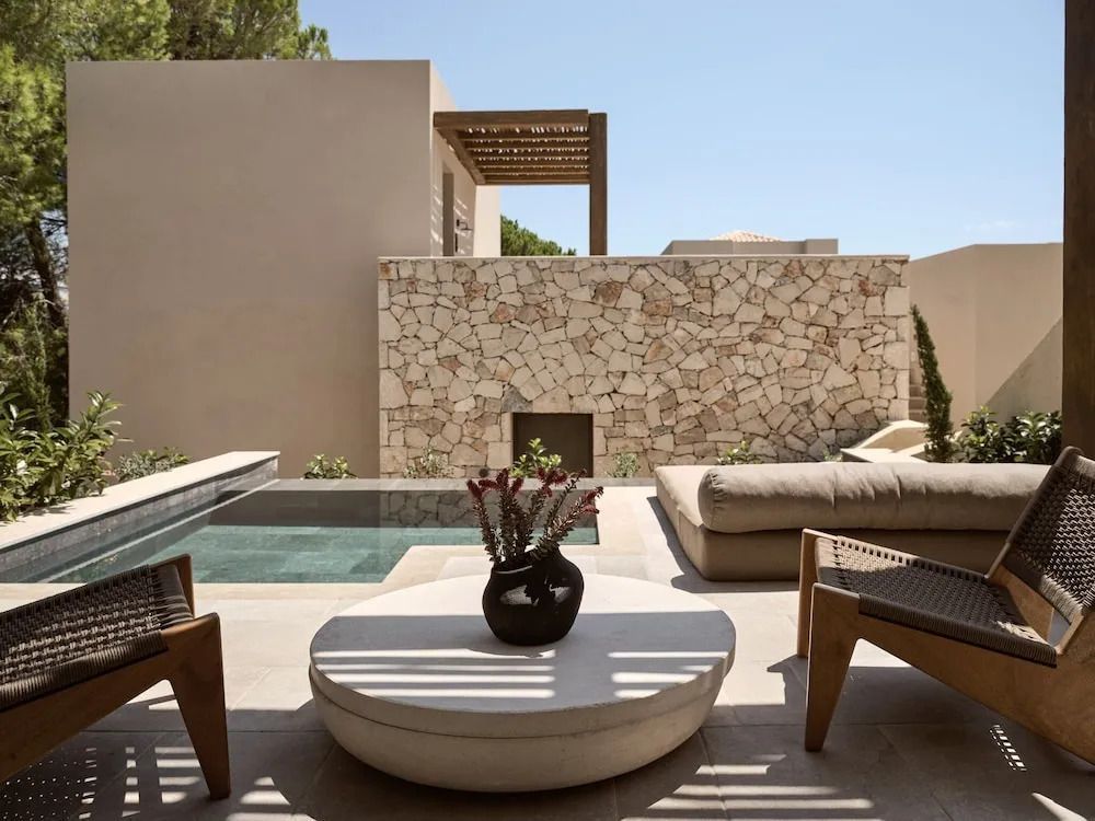 Moderne Terrasse mit Natursteinmauern, Pool und stilvollen Outdoor-Möbeln
