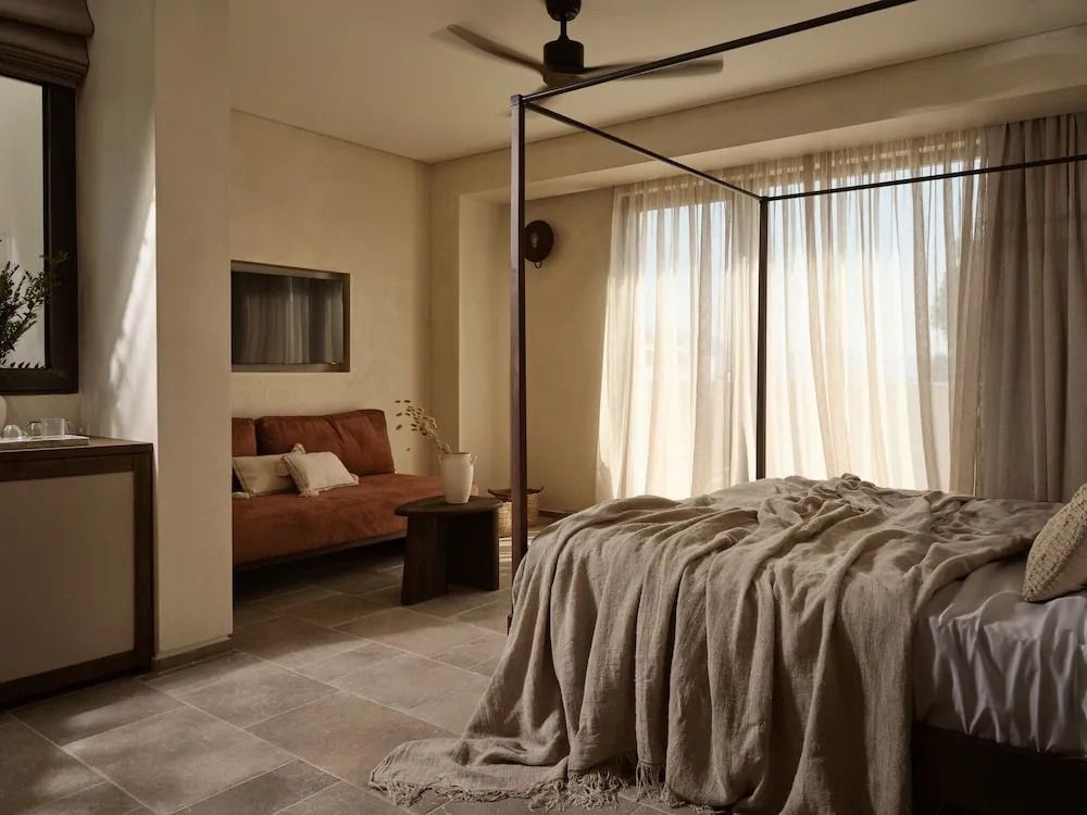 Helles Schlafzimmer mit Himmelbett und großer Fensterfront